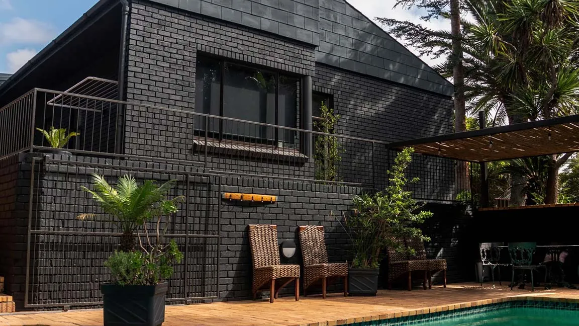 Aurora residence with charcoal brickwork and a landscaped pool terrace