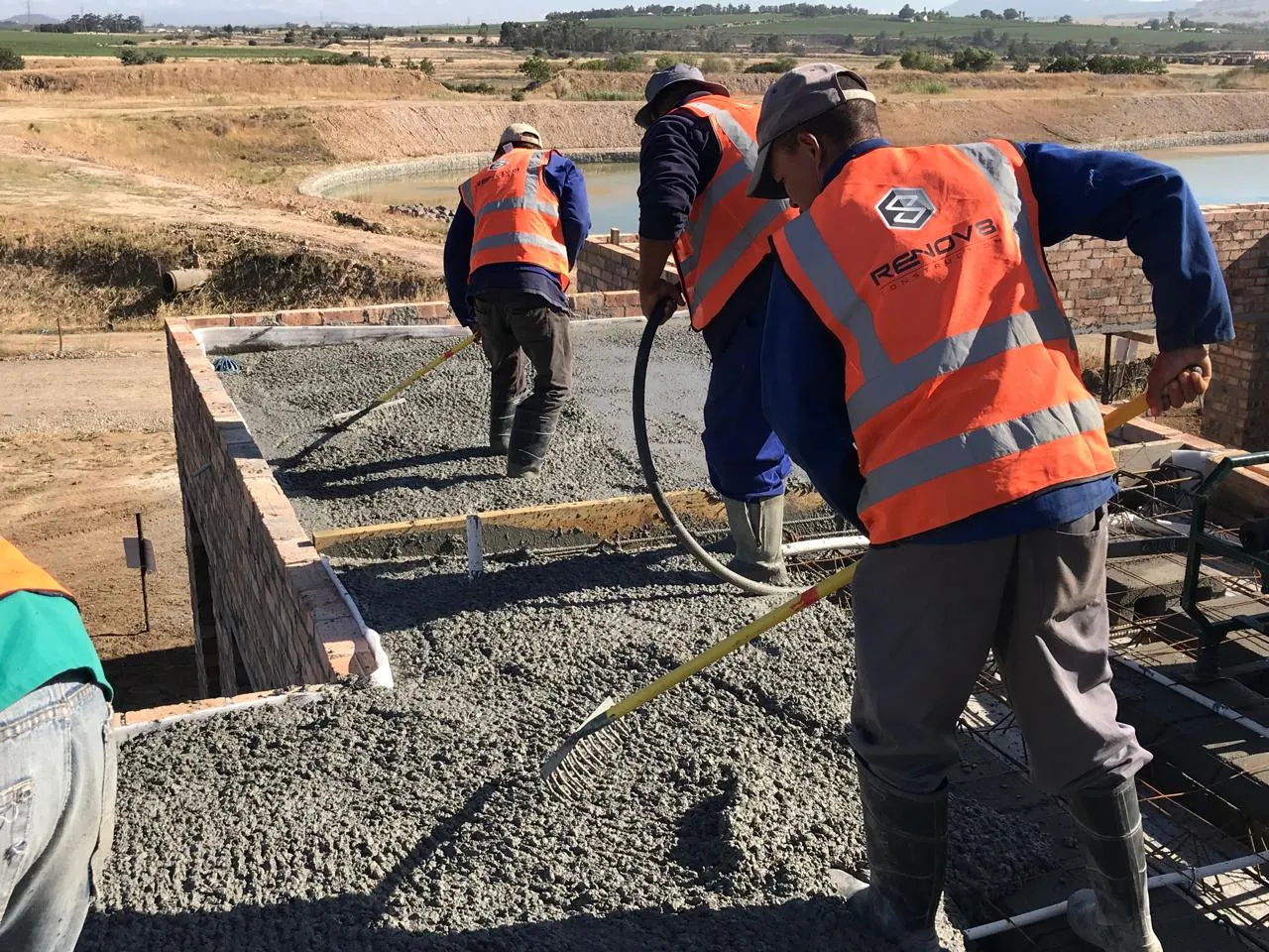 Renov8 team placing concrete on the first-floor slab
