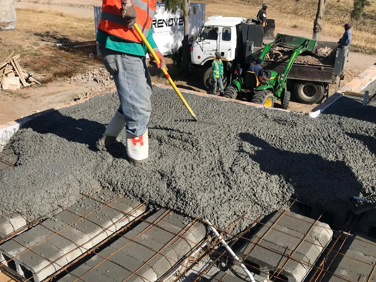 Concrete being raked level over the slab reinforcement