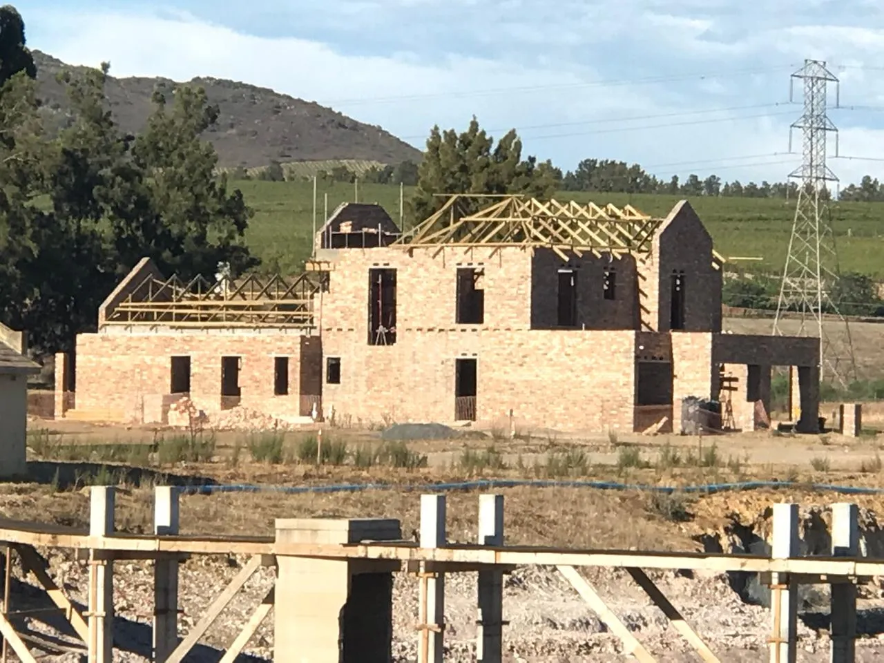 Timber roof trusses on the Devonvale residence, with vineyards behind