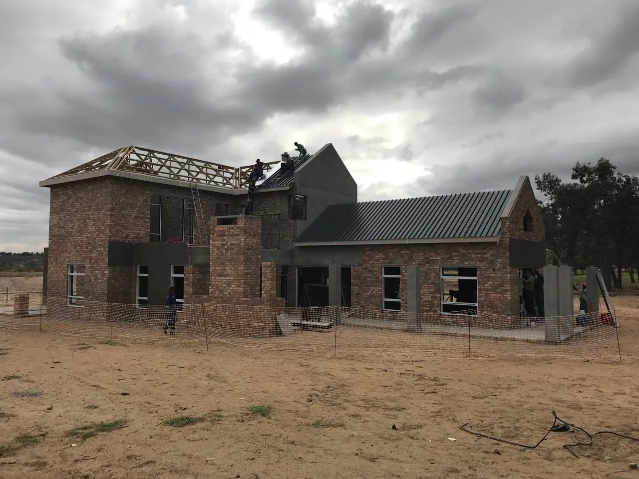 Roof sheeting being fixed over the single-storey wing