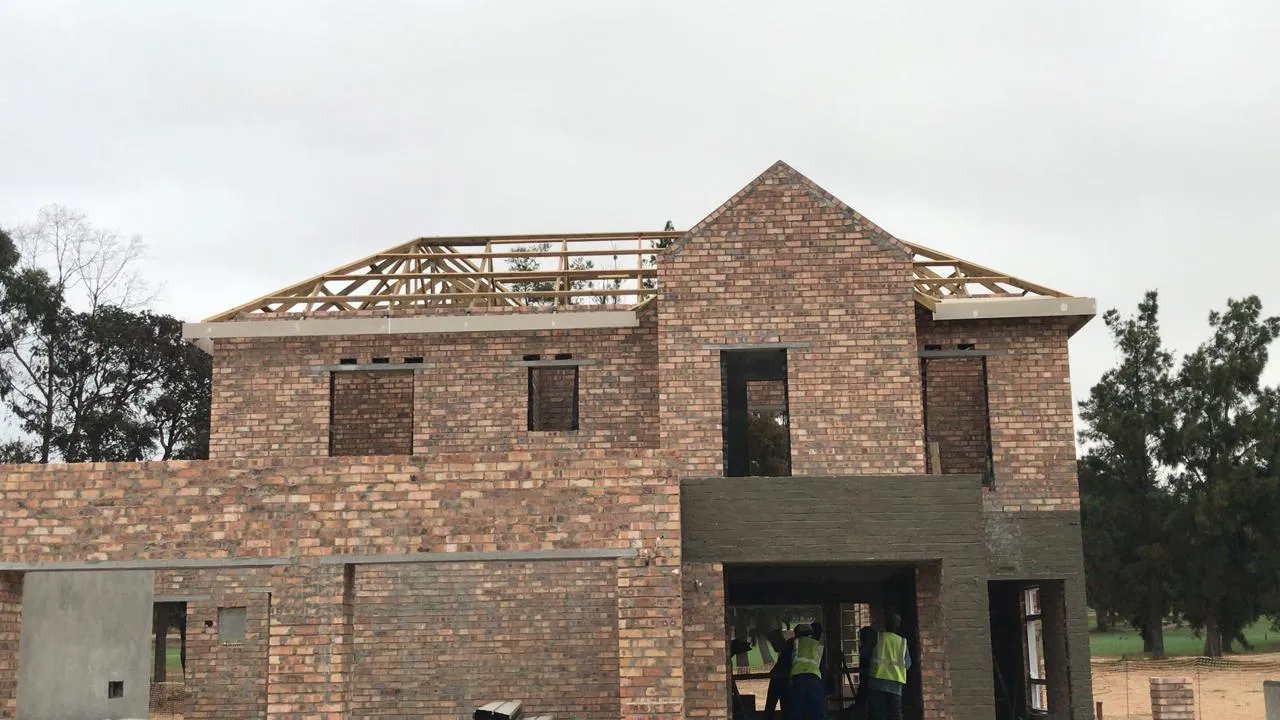 Renov8 team at work below the brick gable and roof trusses